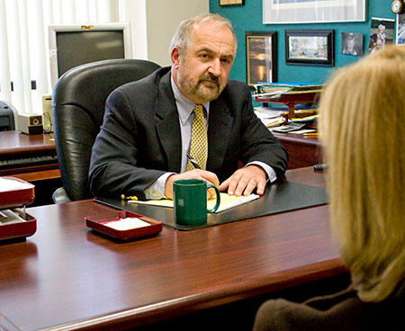 Bruce Blackwell sitting at desk with client